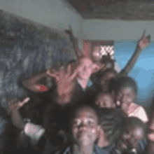 a group of children are posing for a picture with their hands up