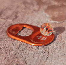 a marble is sitting on a bottle opener that says monster