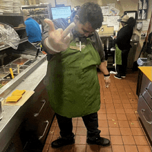 a man wearing a green apron that says panera