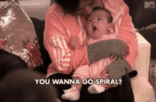 a woman is holding a baby in her arms and says `` you wanna go spiral ? ''