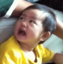 a baby is crying while sitting on a couch .