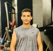 a young man wearing a grey nike tank top