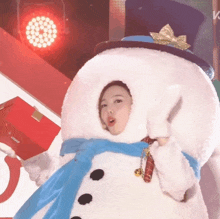 a woman dressed in a snowman costume holds a gift box