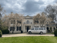 a large white house with a van parked in front of it