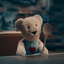 a teddy bear holding a wooden spoon in its paw