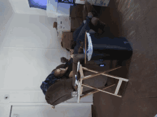 a man sits in a chair with his feet up in front of a stack of boxes with one labeled ' a '