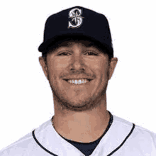 a baseball player wearing a black hat and a white jersey is smiling .