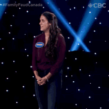 a woman is standing in front of a stage with a name tag on her shirt that says ' shannon ' on it .