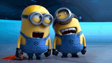 two minions wearing goggles are standing next to each other with their mouths open .