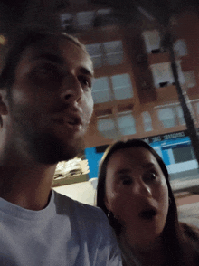 a man and a woman are posing for a picture in front of a building that says ' centro '