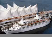 a large cruise ship is docked in front of a building that says canada port