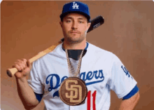 a man wearing a dodgers jersey holds a bat and a gold medal around his neck