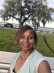 a woman with spanish moss hanging from a tree in the background