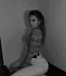 a black and white photo of a woman with a lot of tattoos on her body