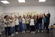 a group of people are raising their hands in the air in front of a board that says " o nosso "