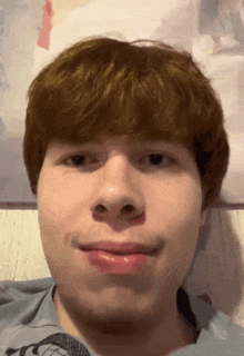 a close up of a man 's face with red hair and a blue shirt