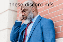 a man leaning against a brick wall with his hand on his forehead and the words these discord mfs written above him