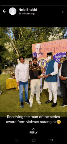 a group of men are standing in front of a sign that says " receiving the man of the series award from vishwas sarang sir "