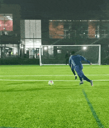 a man kicking a soccer ball on a field with a building in the background that says buy it live