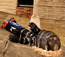 a statue of a man is laying on the ground with a knife in his hand and a bandana that says police