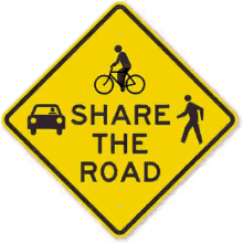 a sign that says share the road with a car and a pedestrian