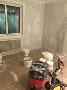 a room with buckets of paint and a vacuum