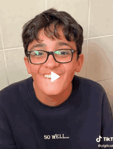 a young boy wearing glasses and a black shirt that says so well on it