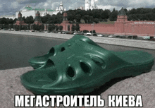 a pair of green slippers are sitting on a ledge in front of a river .