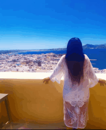 a woman standing on a balcony overlooking the ocean