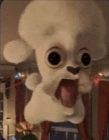 a stuffed animal with its tongue out is floating in the air in a living room .