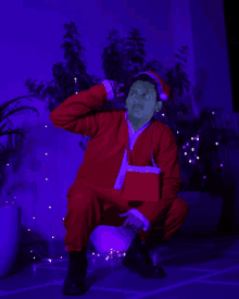 a man dressed in a santa suit is kneeling down