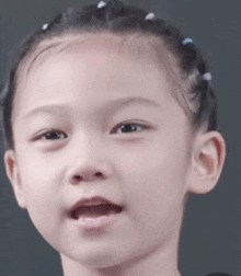 a close up of a young girl 's face with her mouth open .