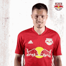 a man is wearing a red bull jersey and smiling