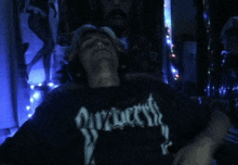 a man wearing a black shirt that says ' nocturnus ' on it