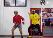 a man in a yellow shirt is dancing with a girl in a red sweater