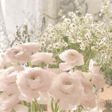 a bunch of pink and white flowers in a vase on a table