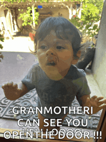 a baby looking out a window with the words " granmotheri can see you open the door "