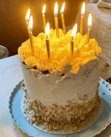 a cake with yellow frosting and candles on it