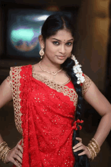 a woman with long black hair wearing a red dress and gold jewelry