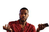 a man in a red leopard print shirt holds a cell phone