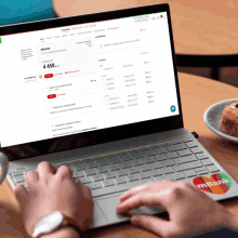 a person is typing on a laptop with a mastercard sticker on it