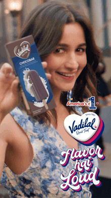 a woman holds up a vadilal chocobar ice cream bar