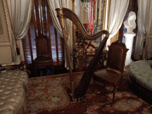 a harp sits in a living room next to a chair and ottoman