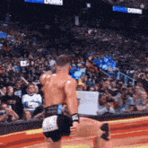 a wrestler in a wrestling ring with a crowd behind him and a sign that says ' down ' on it