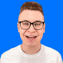 a young man wearing glasses and a white shirt smiles