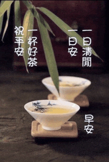 two cups of tea are sitting on a wooden table with chinese writing on it .