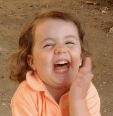 a little girl is laughing with her mouth open