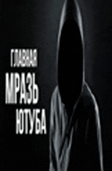 a man in a hooded jacket is standing in the dark with russian writing behind him .