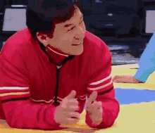 a pixelated image of a man in a red jacket giving two thumbs up