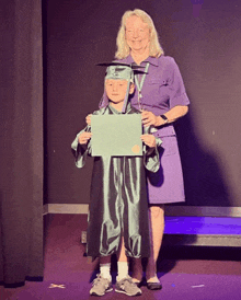 a girl in a graduation cap and gown is holding a certificate